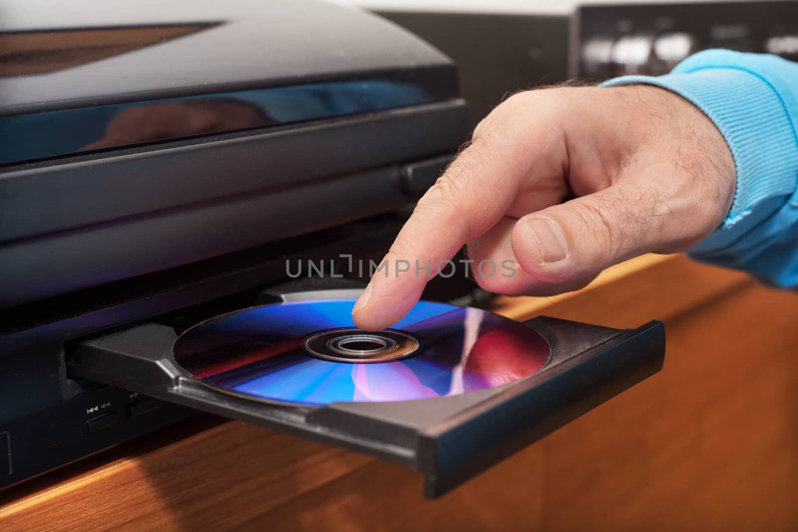 Hand holding DVD inserting to video player by HERRAEZ