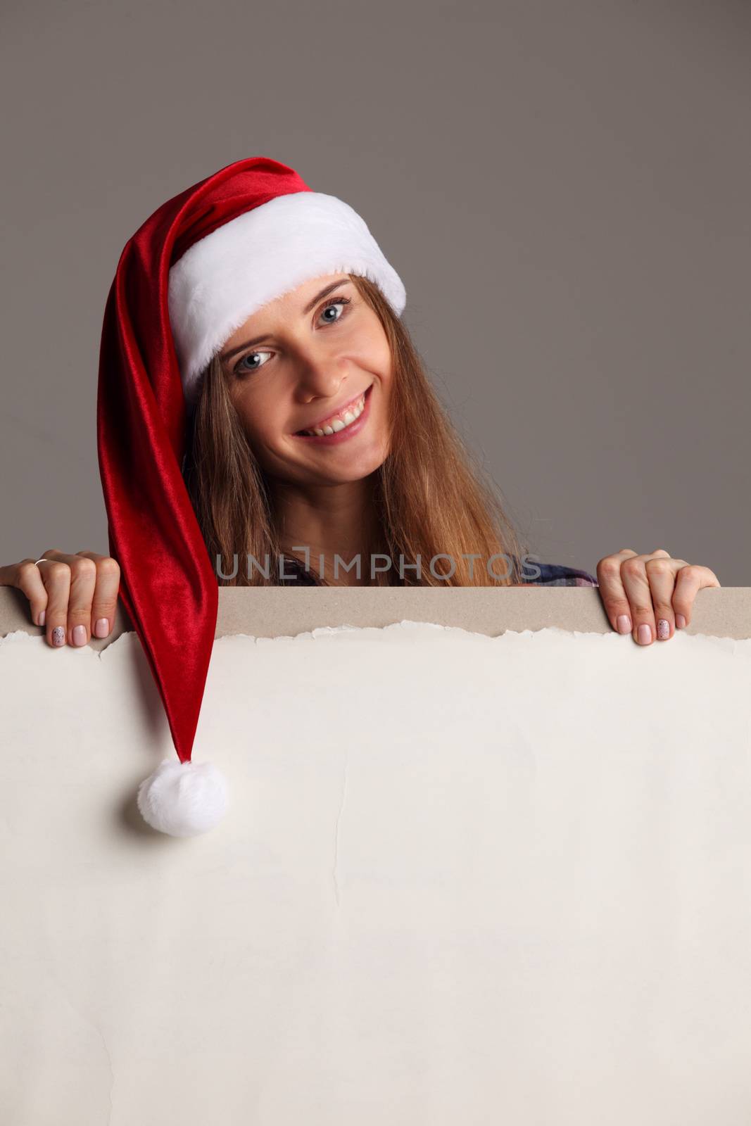 Santa girl holding blank vintage sign billboard. Christmas woman in Santa hat showing paper sign.