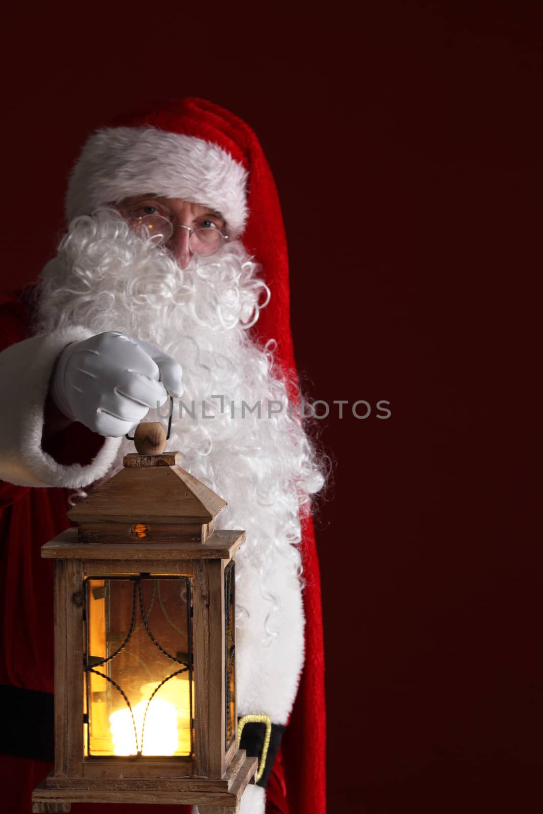 Santa Claus holding retro style lantern , dark red background