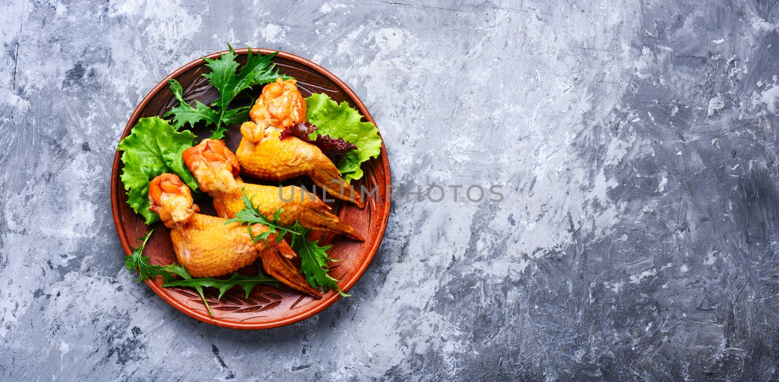 Smoked chicken wings and leaf salad. Fast food.American Cuisine