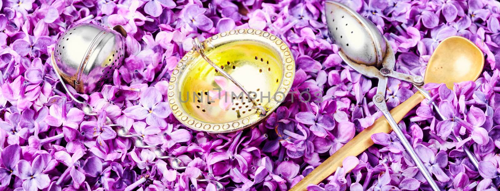 Tea background with lilac flowers and tea attributes. Herbal tea.