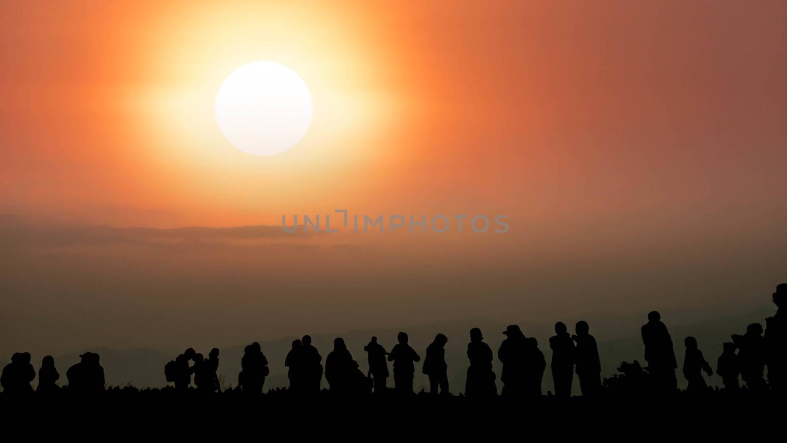 Landscape with silhouette of people on the mountain  with background of cloudy sky and sun