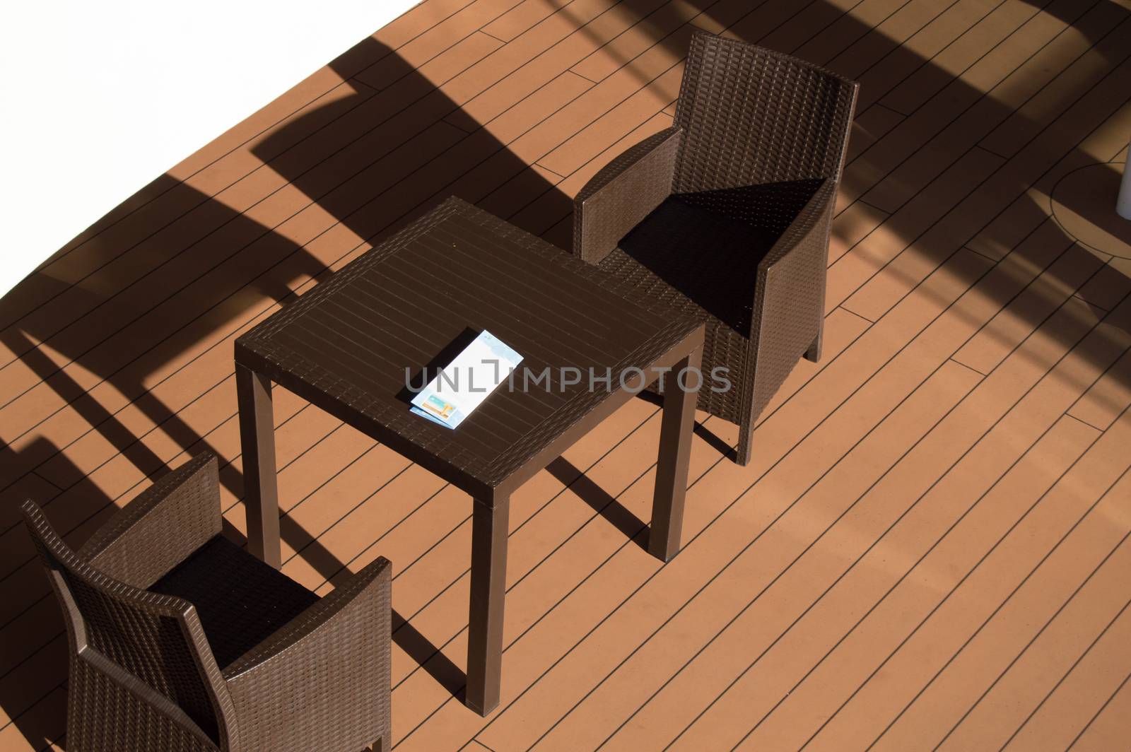 Dark table and chairs of the restaurant on the open deck of the cruise ship, top view.