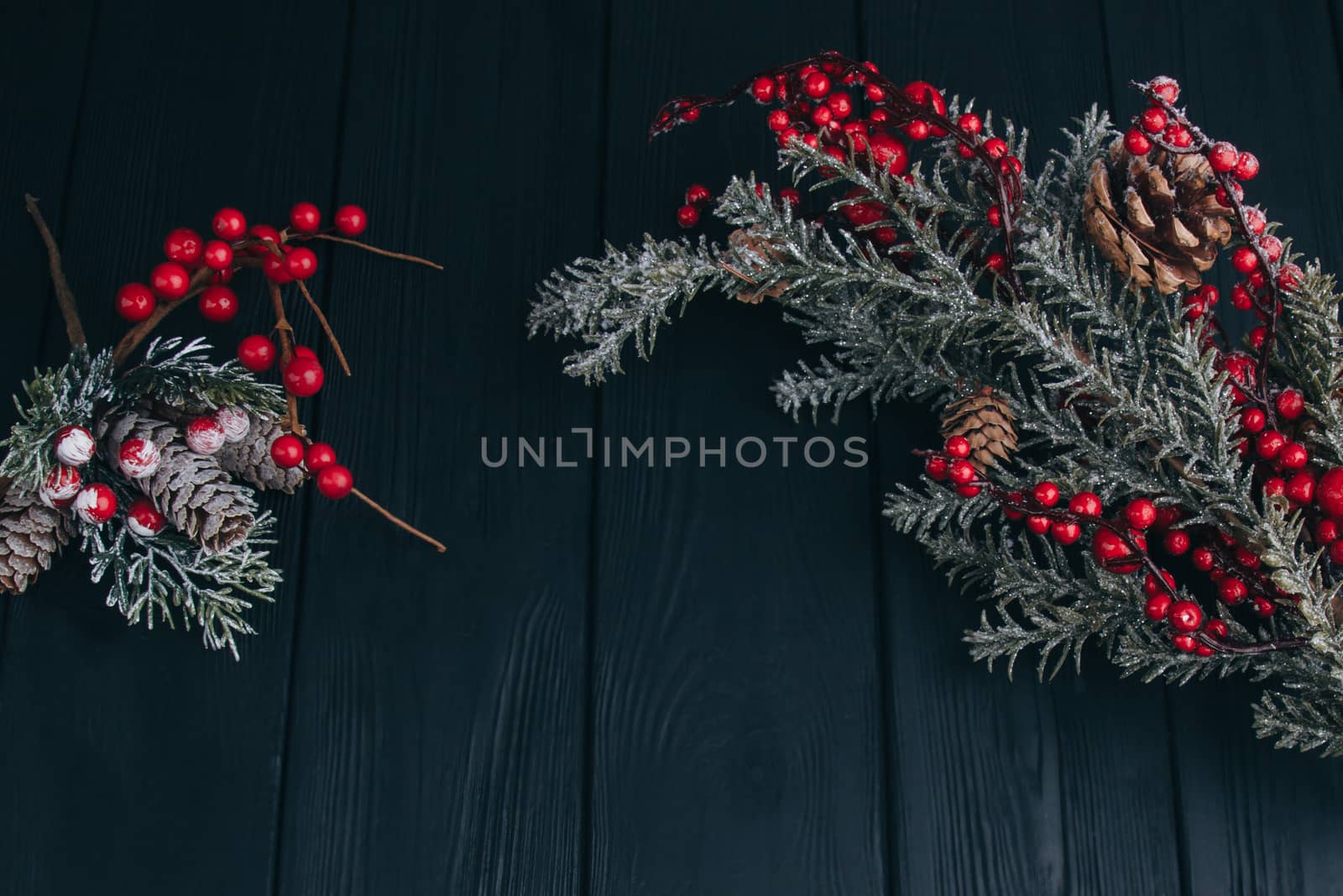 Christmas composition. Fir branches needles and berries of viburnum on a black background. New Year's composition