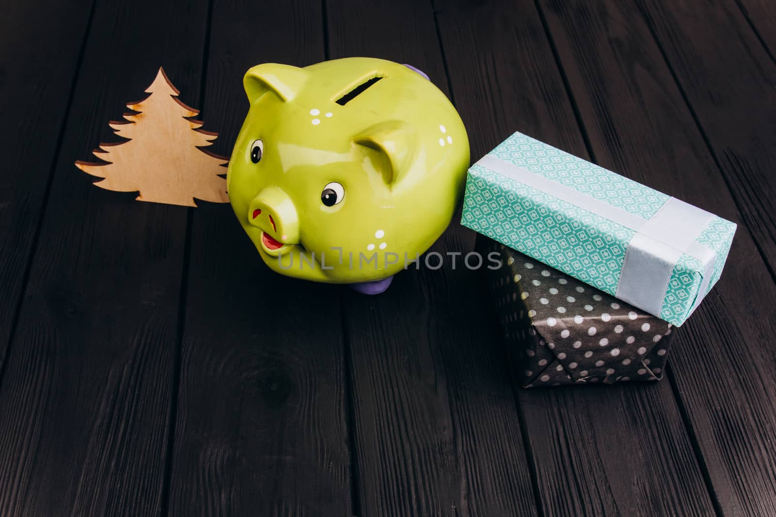 Cute smiling green Piggy Bank on the Wooden Table by yulaphotographer