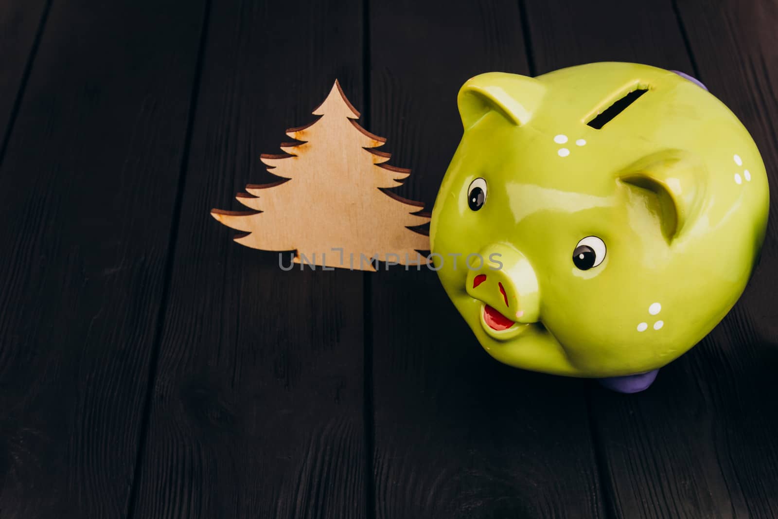 Cute smiling green Piggy Bank on the Wooden Table by yulaphotographer