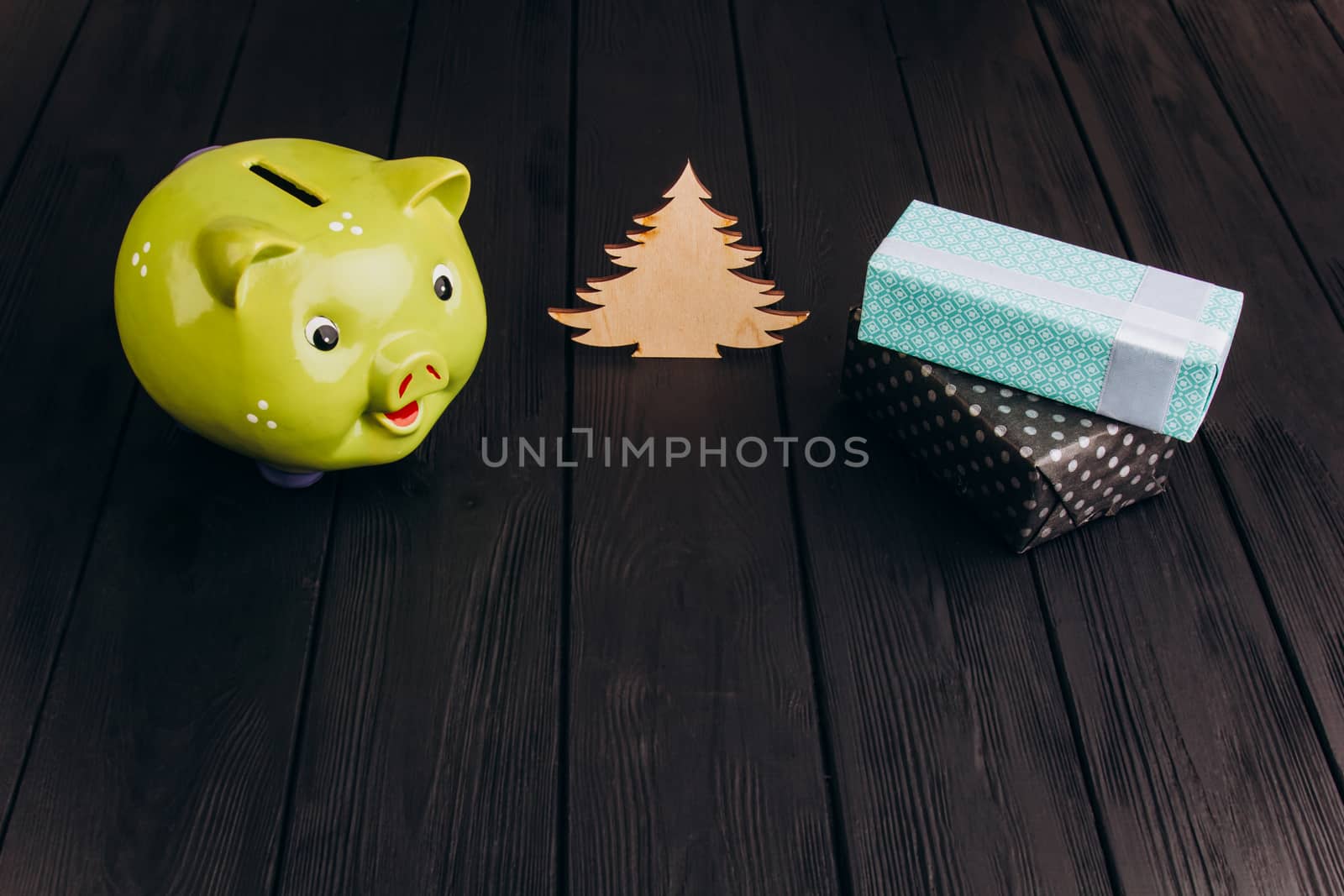 Cute smiling green Piggy Bank on the Wooden Table by yulaphotographer