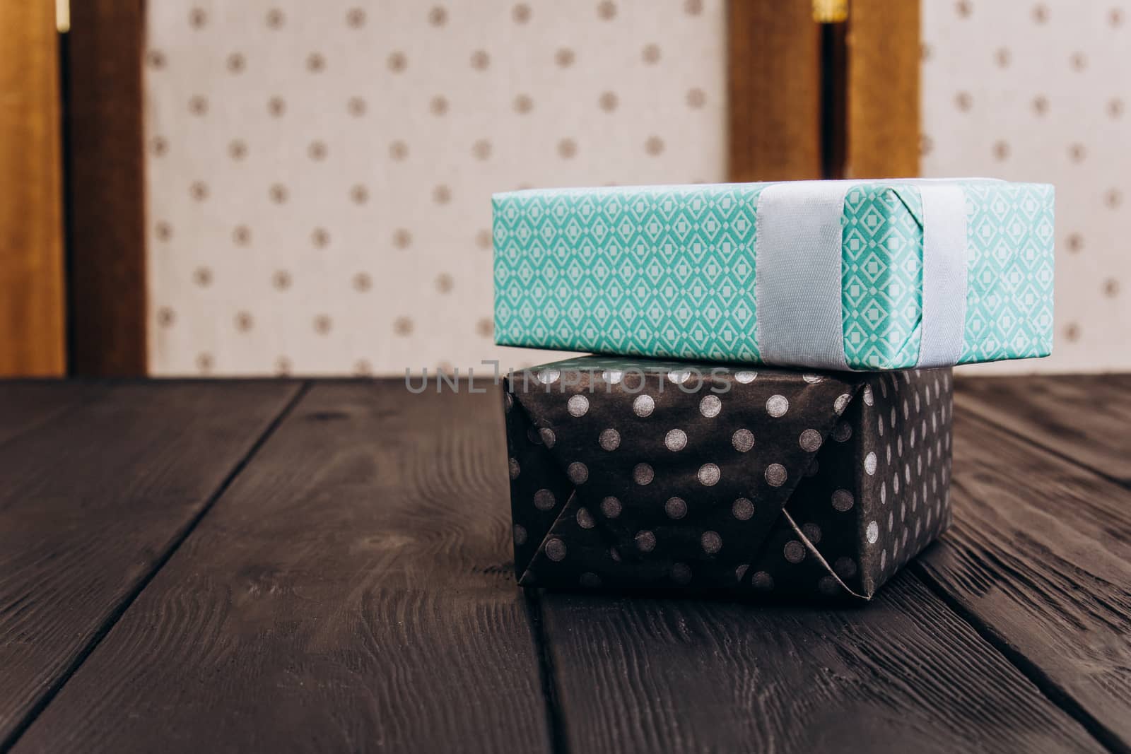 black and blue gift boxes on dark wood table background by yulaphotographer