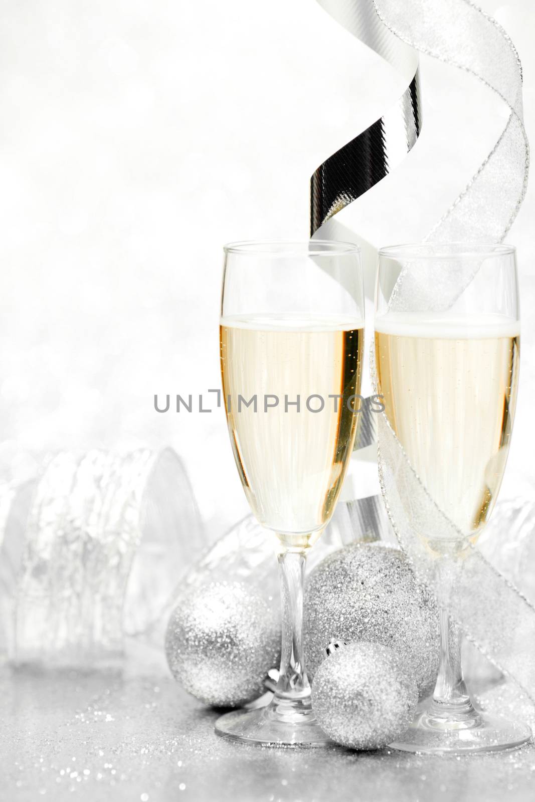 Glasses of champagne and  christmas decorative balls on glitter background