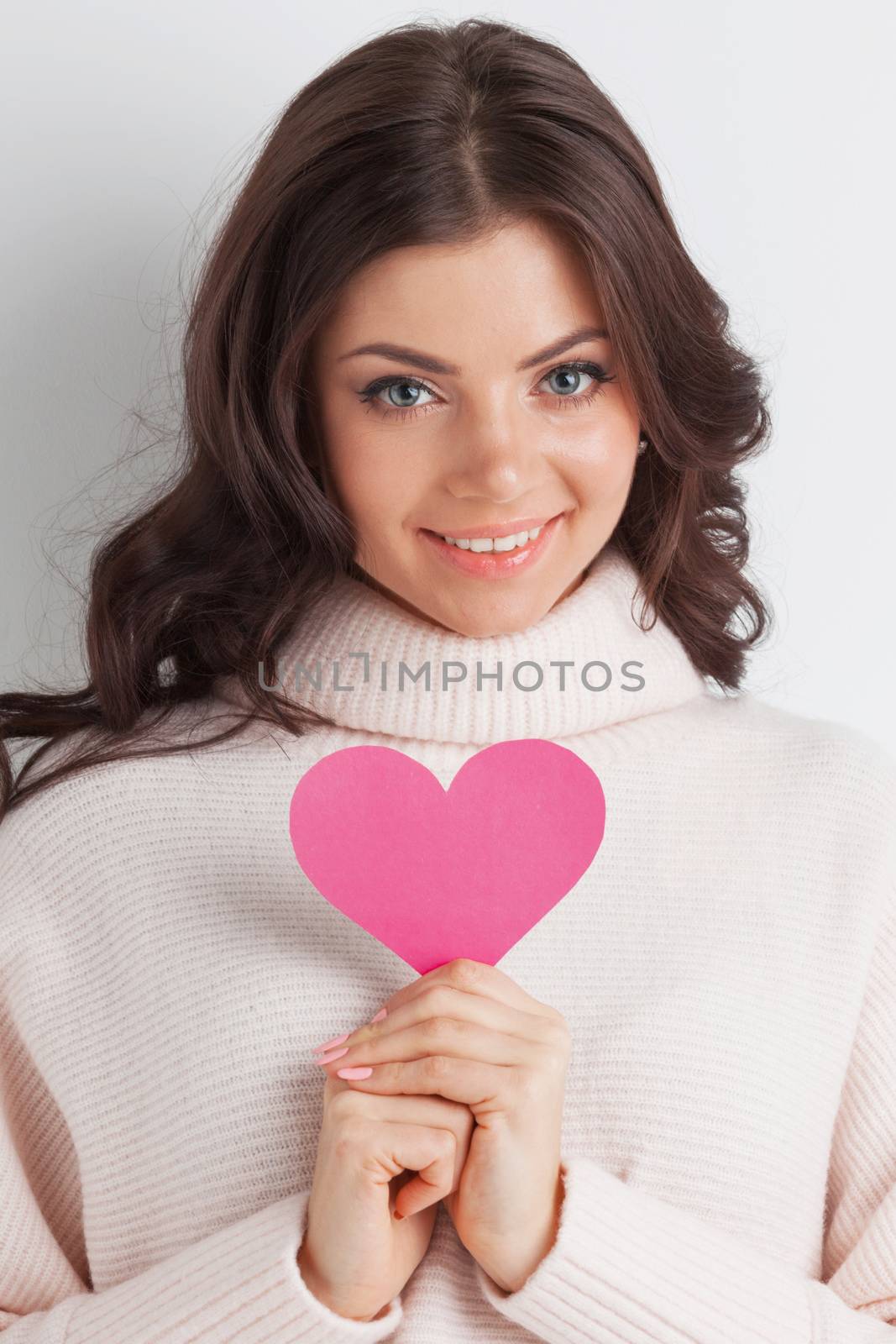 Happy young smiling woman with pink paper heart