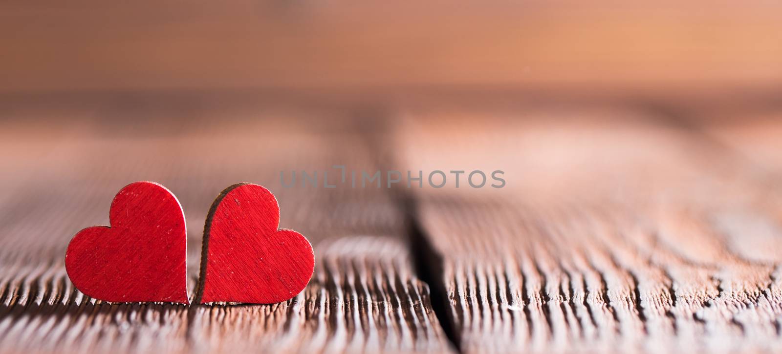 Two small wooden red hearts on old cracked wood background