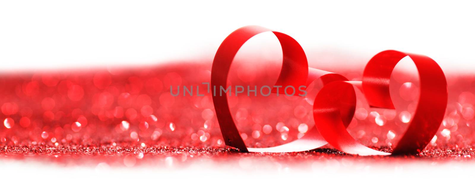 Red ribbon hearts on glitters isolated on white, Valentines day concept