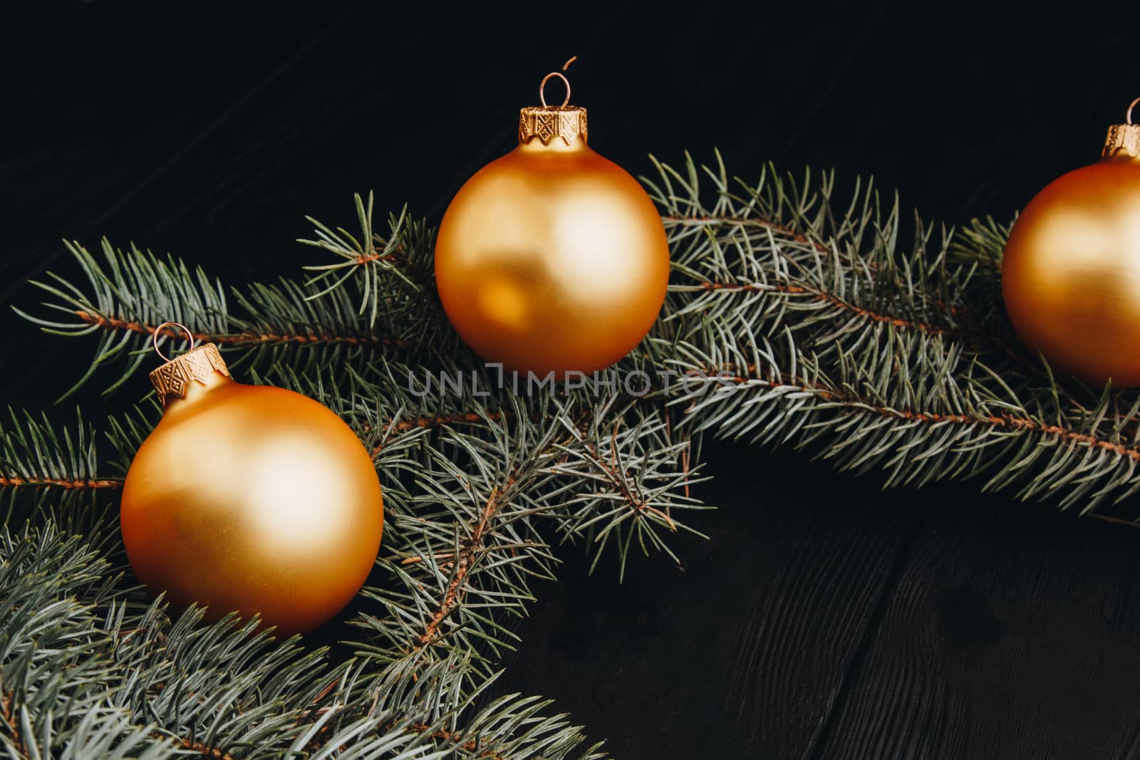 Christmas or New Year toy decorations golden ball and fur tree branch rustic on wooden background, top view, copy space