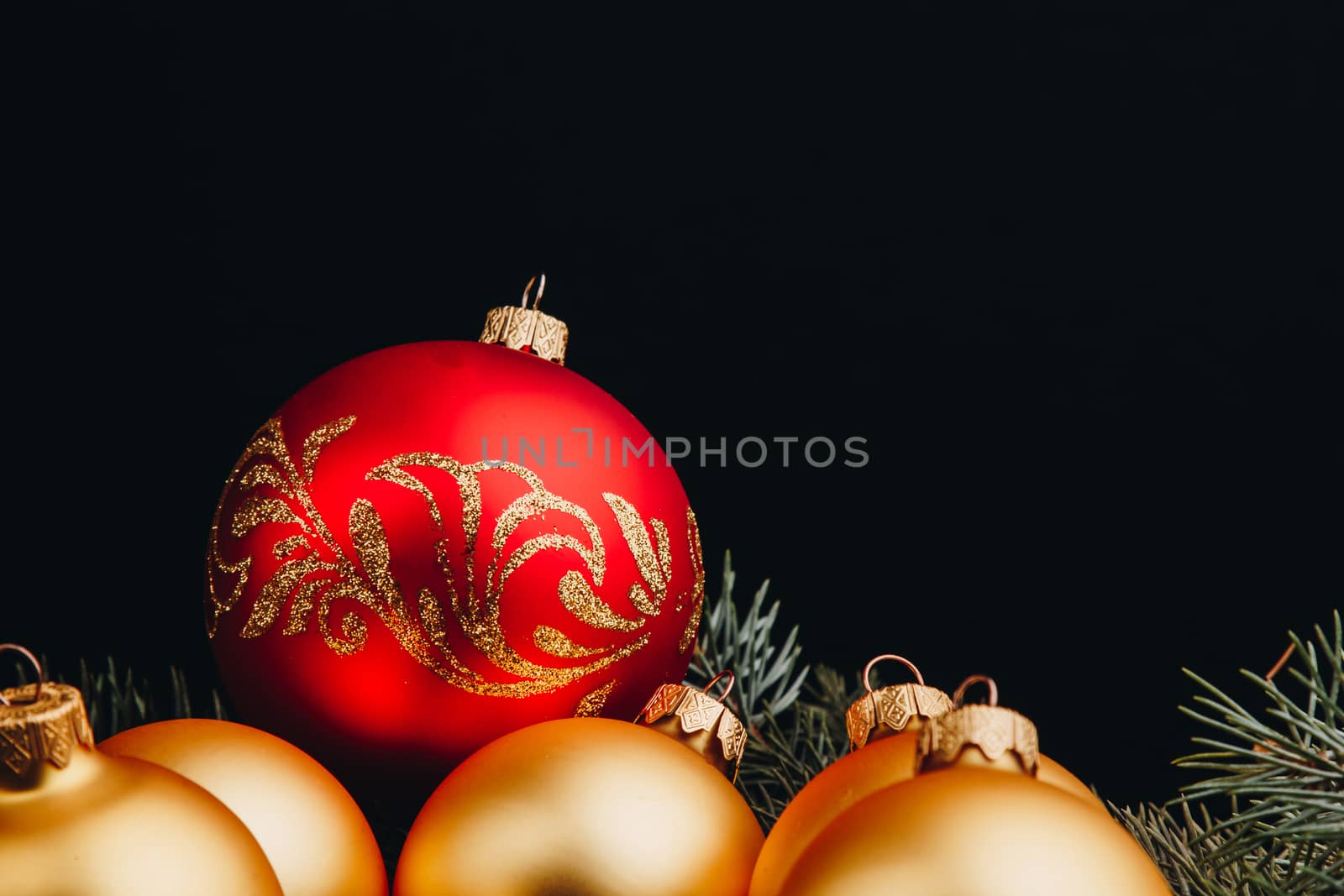 Christmas or New Year toy decorations golden balls and fur tree branch rustic on wooden background, top view, copy space by yulaphotographer