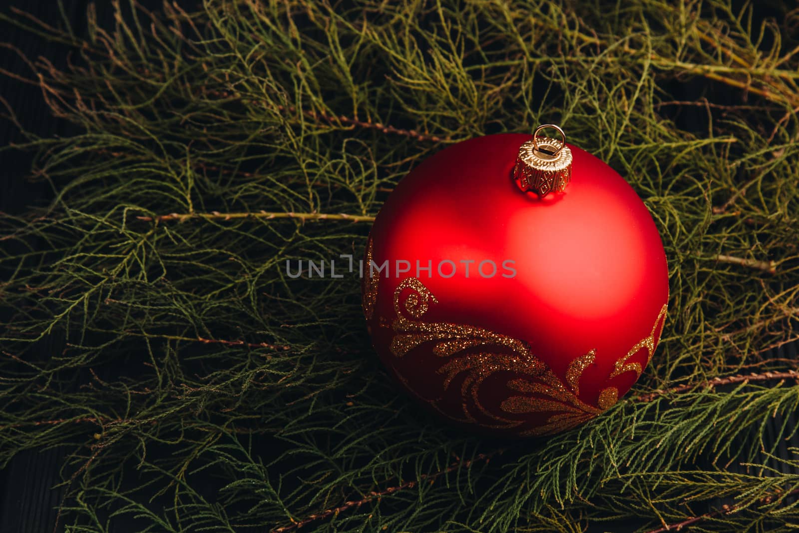 Christmas New Year decoration composition. Top view of fur-tree branches and balls frame on wooden background with place for your text.