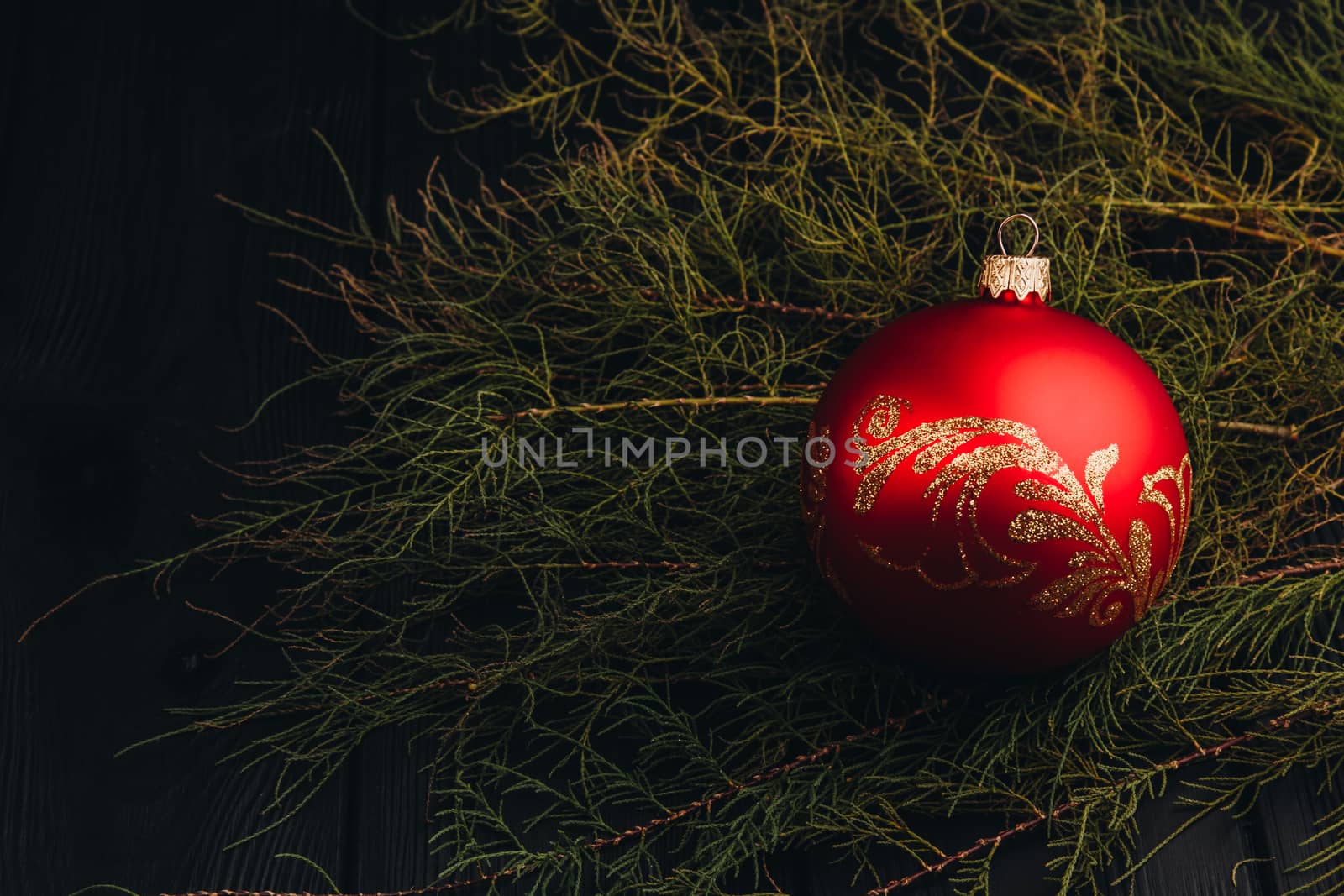 Christmas New Year decoration composition. Top view of fur-tree branches and balls frame on wooden background with place for your text.