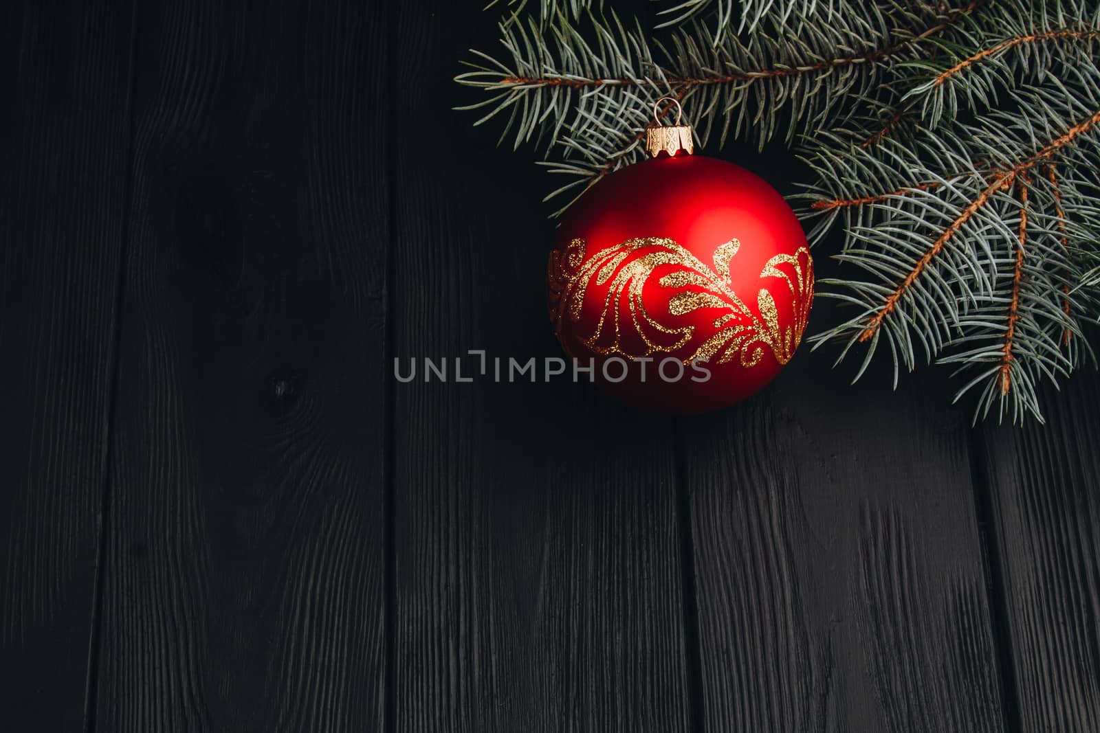 Christmas New Year decoration composition. Top view of fur-tree branches and balls frame on wooden background with place for your text.