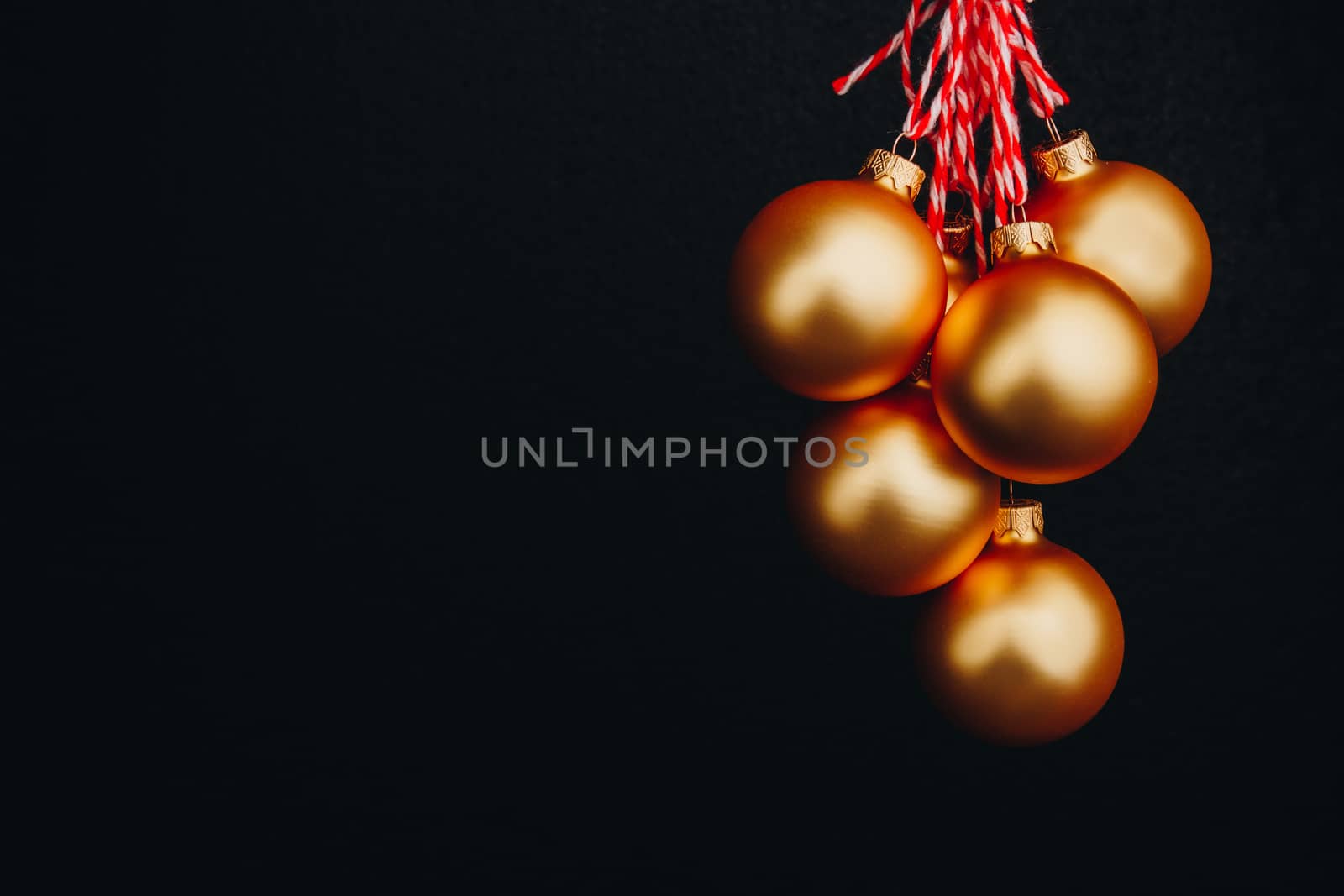 golden Christmas balls in hand isolated on black background. new year card