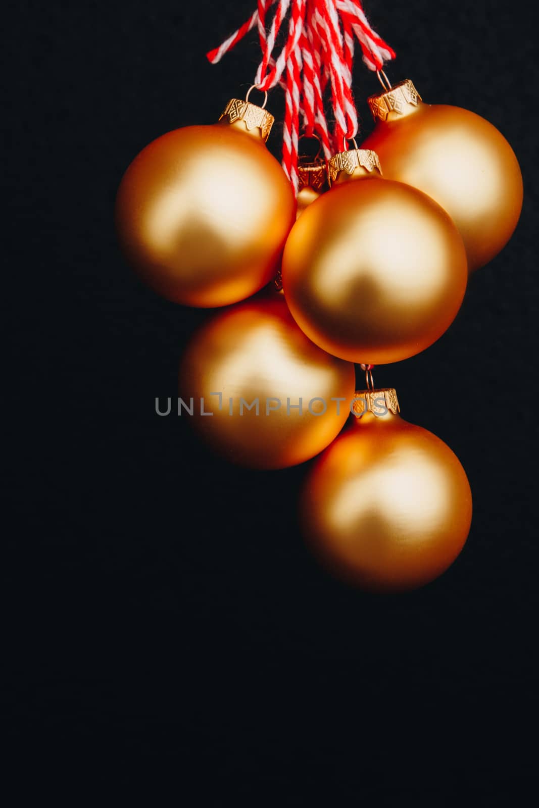 golden Christmas balls in woman's hand isolated on black background. new year card by yulaphotographer