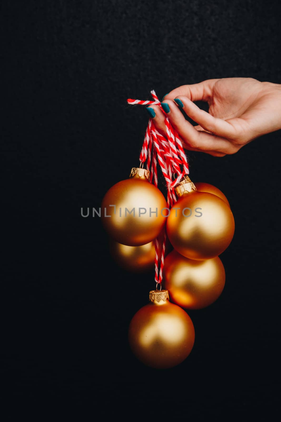 golden Christmas balls in hand isolated on black background. new year card