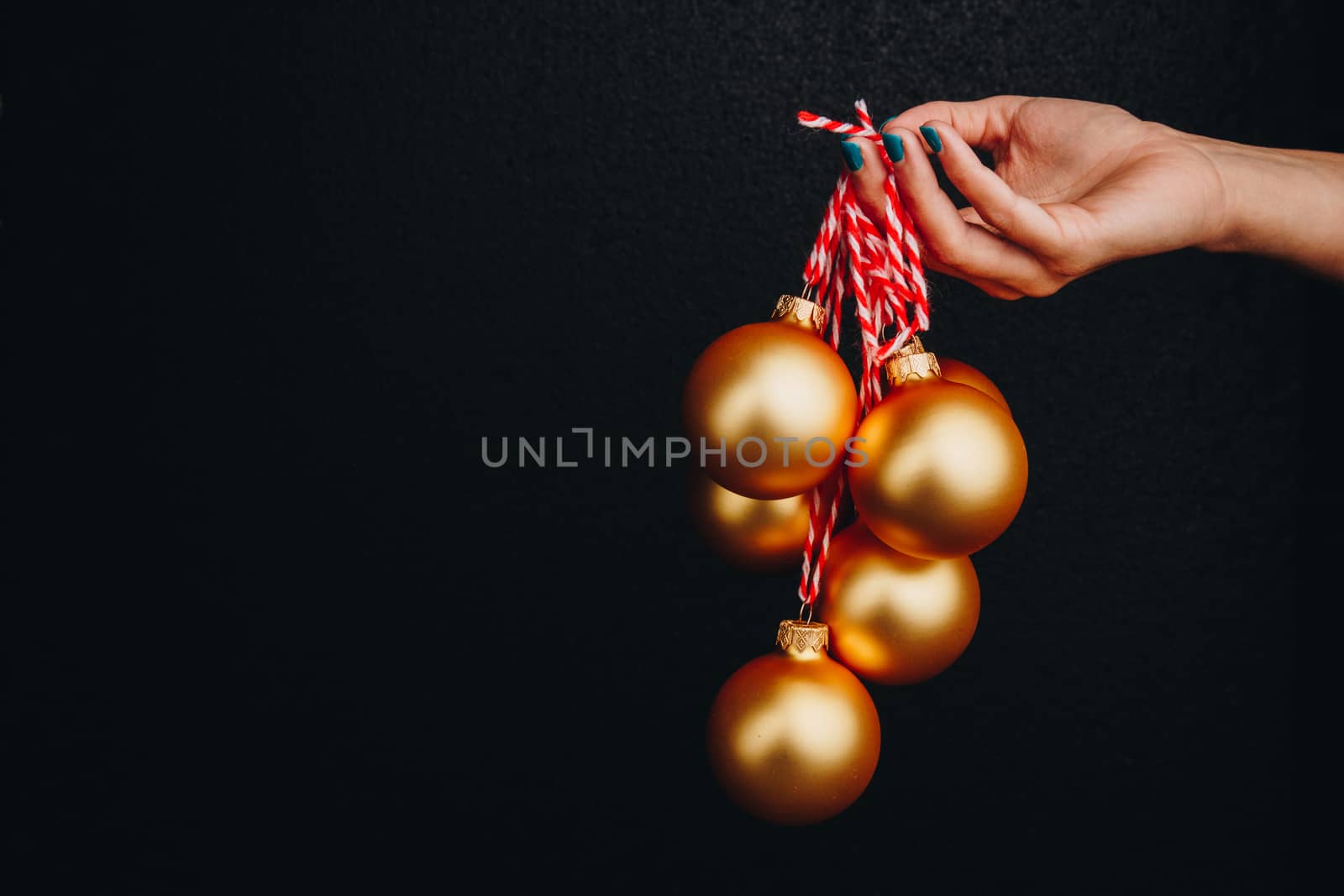 golden Christmas balls in hand isolated on black background. new year card