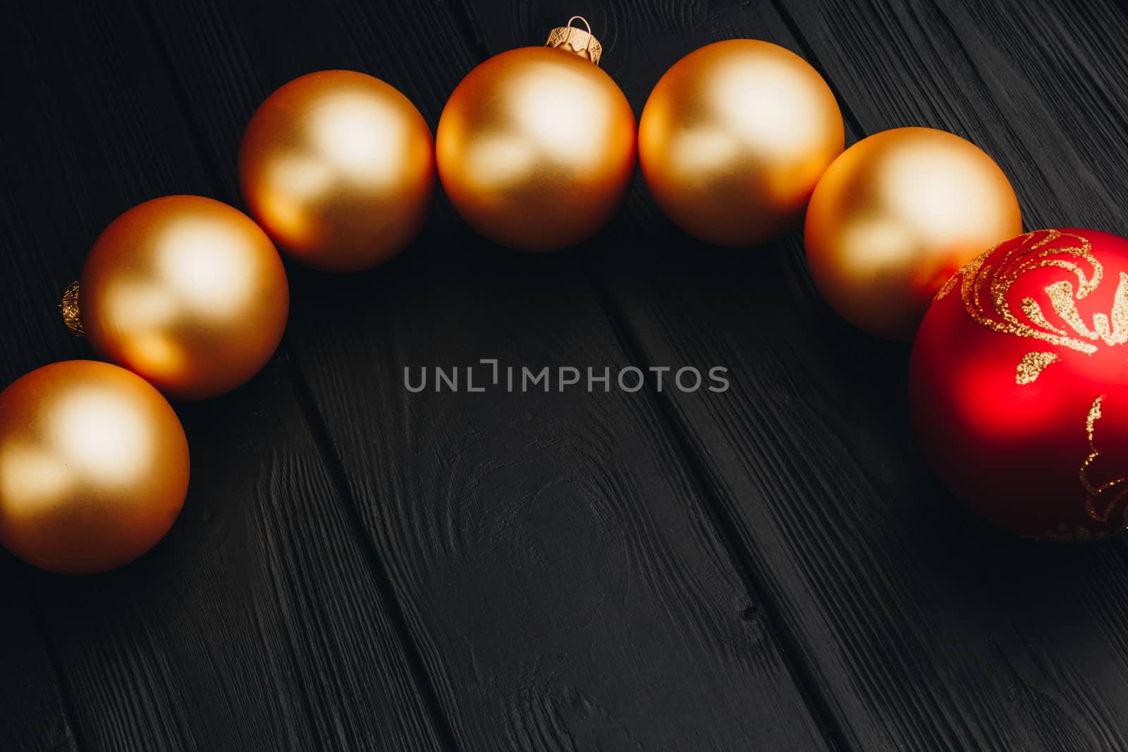 Colored christmas decorations on black wooden table. Xmas balls on wooden background. Top view, copy space. new year by yulaphotographer