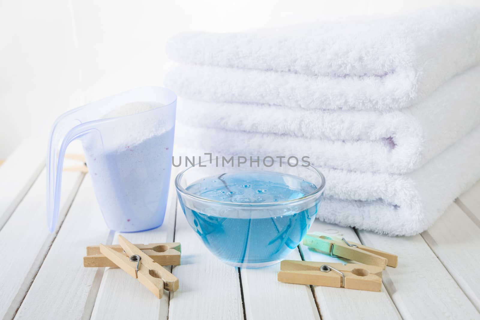 Bath towels, washing powder, fabric softener and wooden clothesp by Epitavi