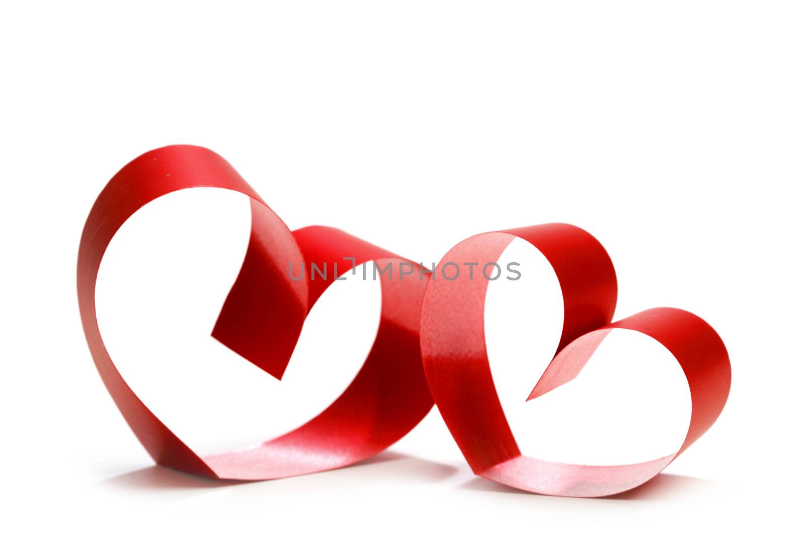 Two linked hearts of red ribbon isolated on white background