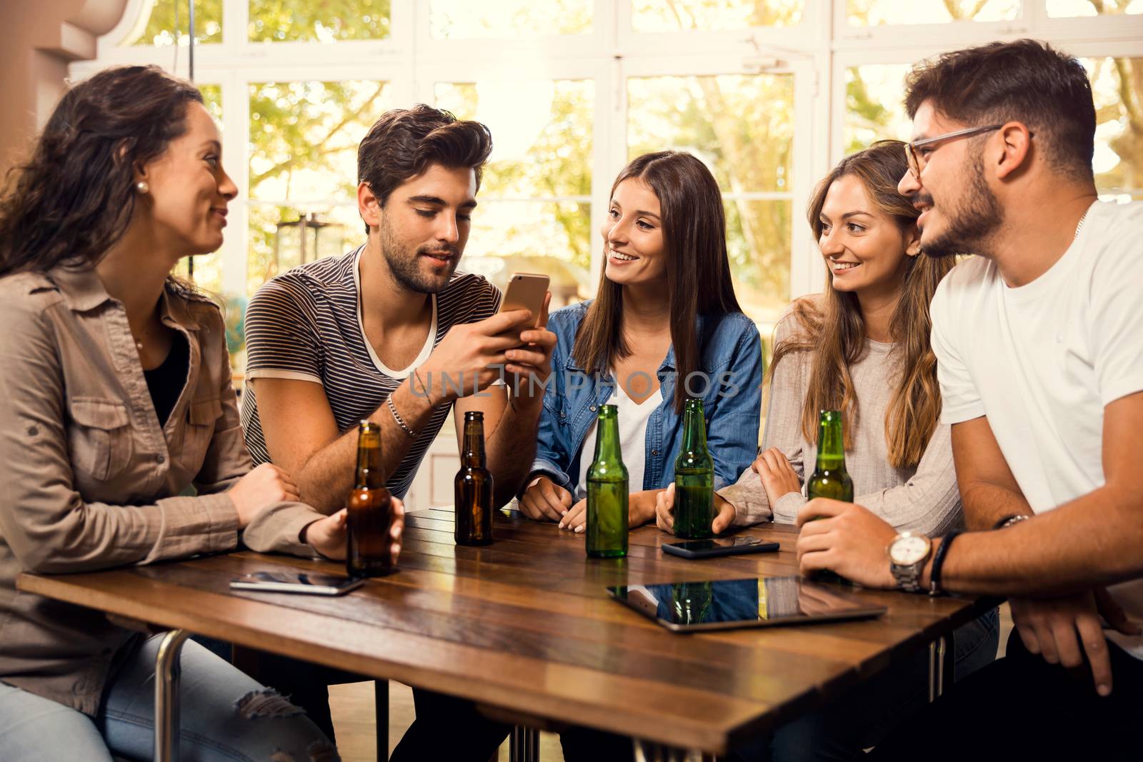 A group of friends at the bar drinking a beer 