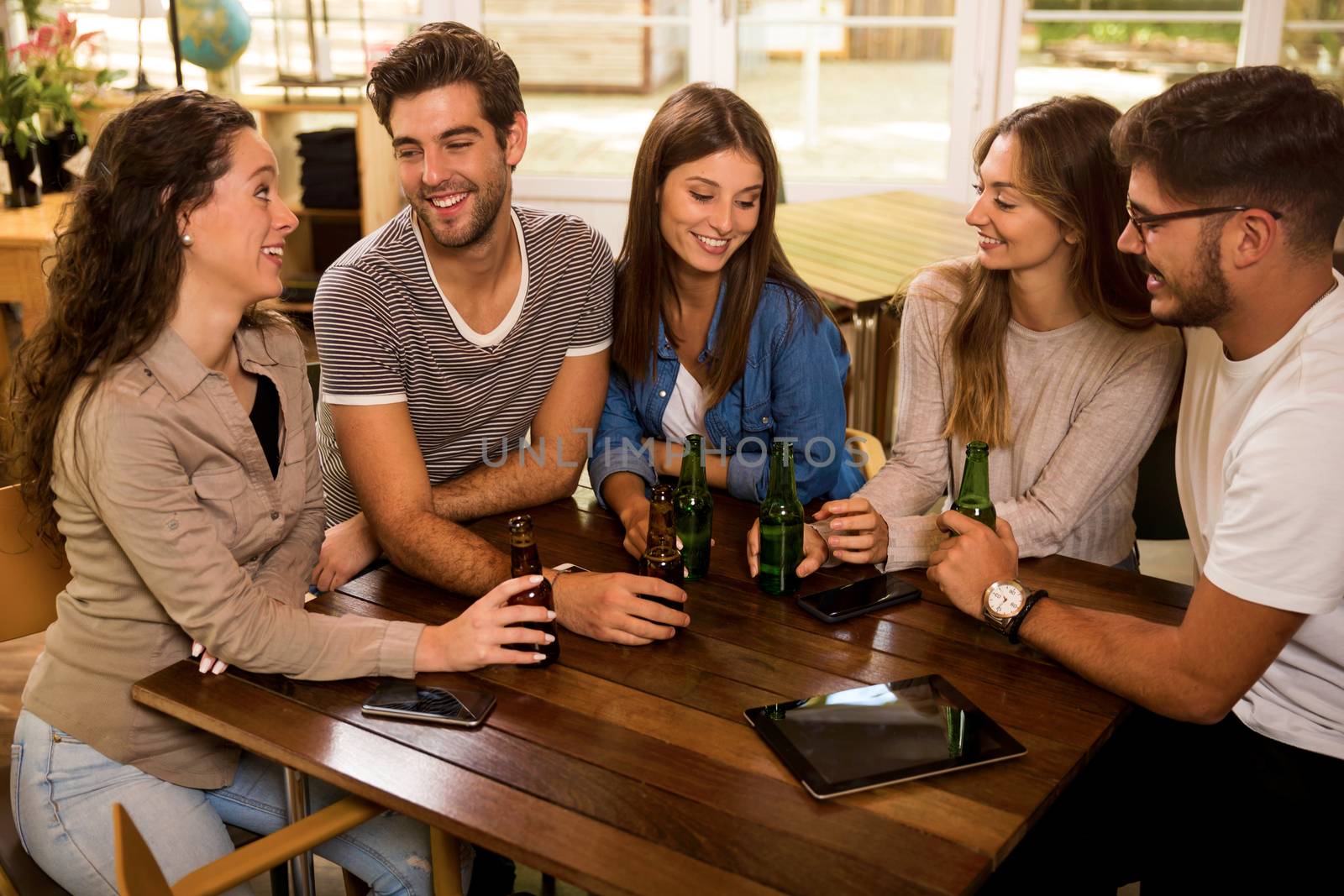 A group of friends at the bar drinking a beer 