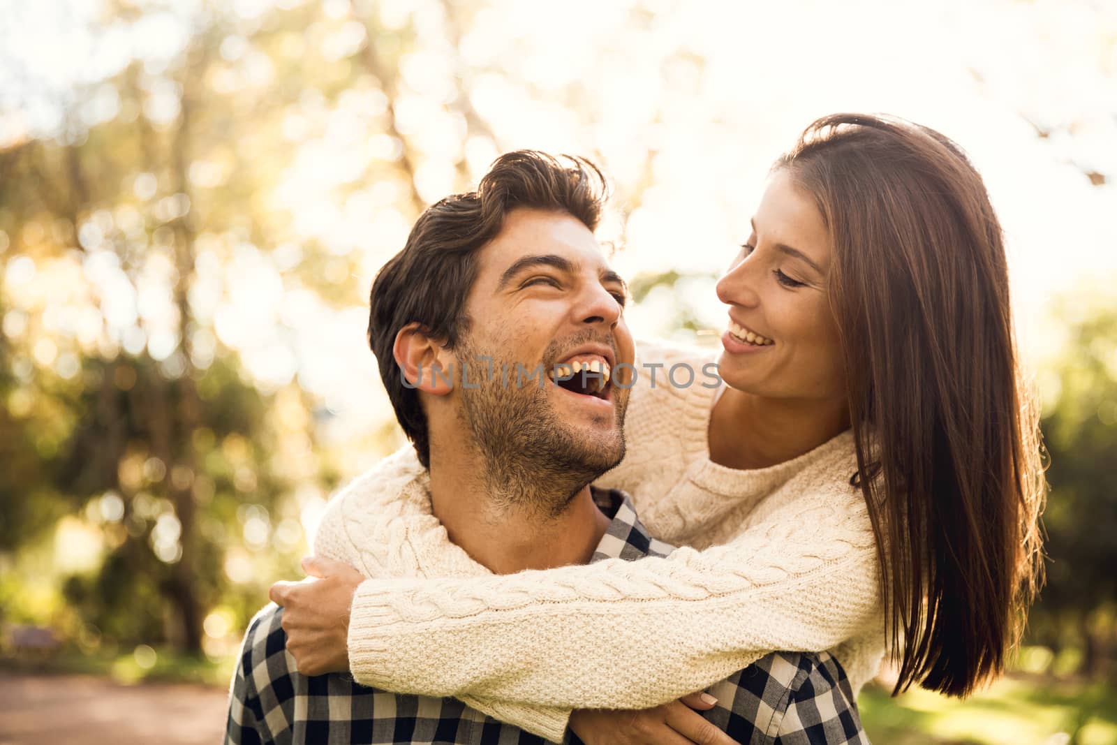 Happy couple in the park looking at each other and laughing