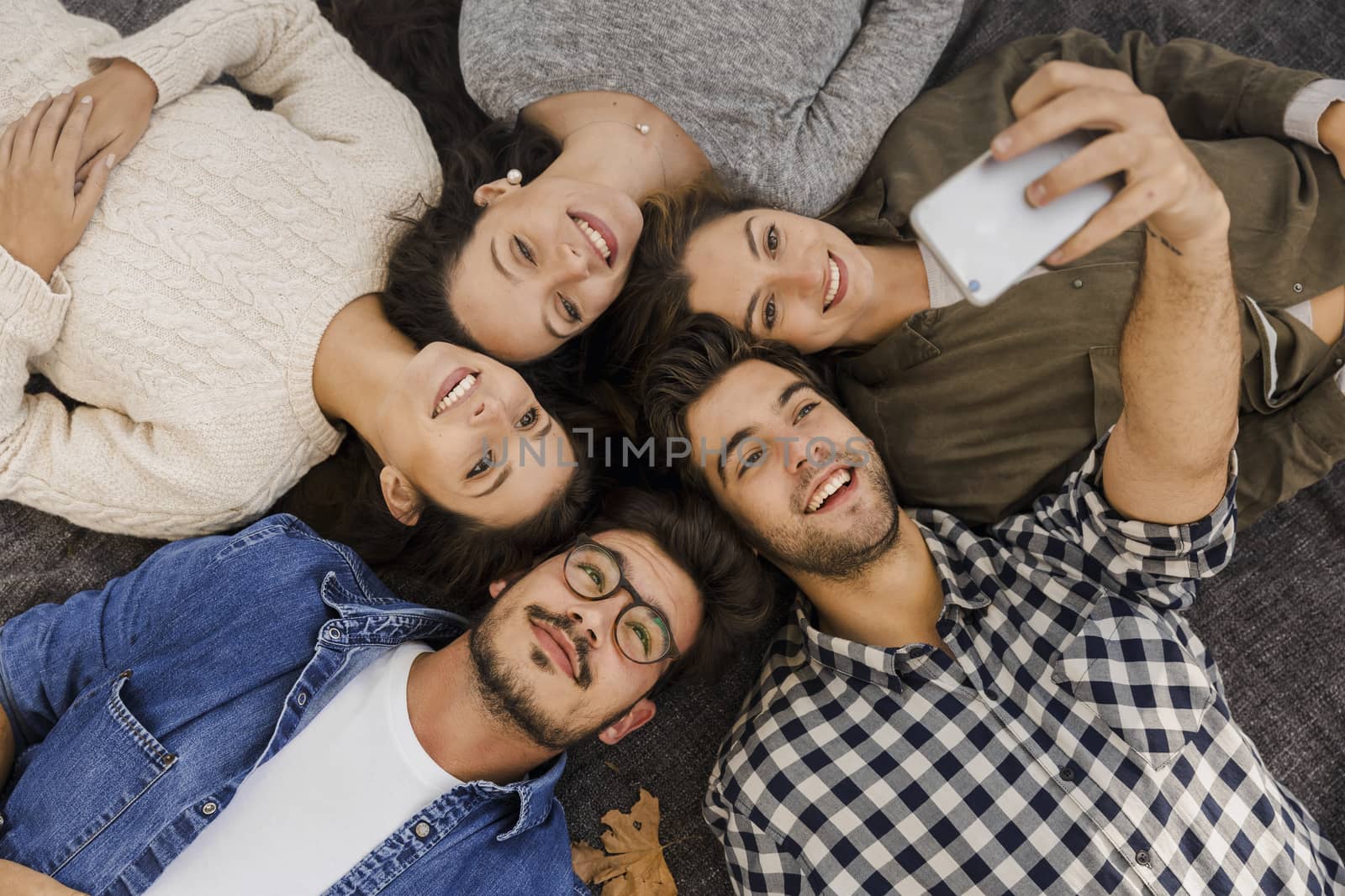 Friends in the park having fun and making a group selfie