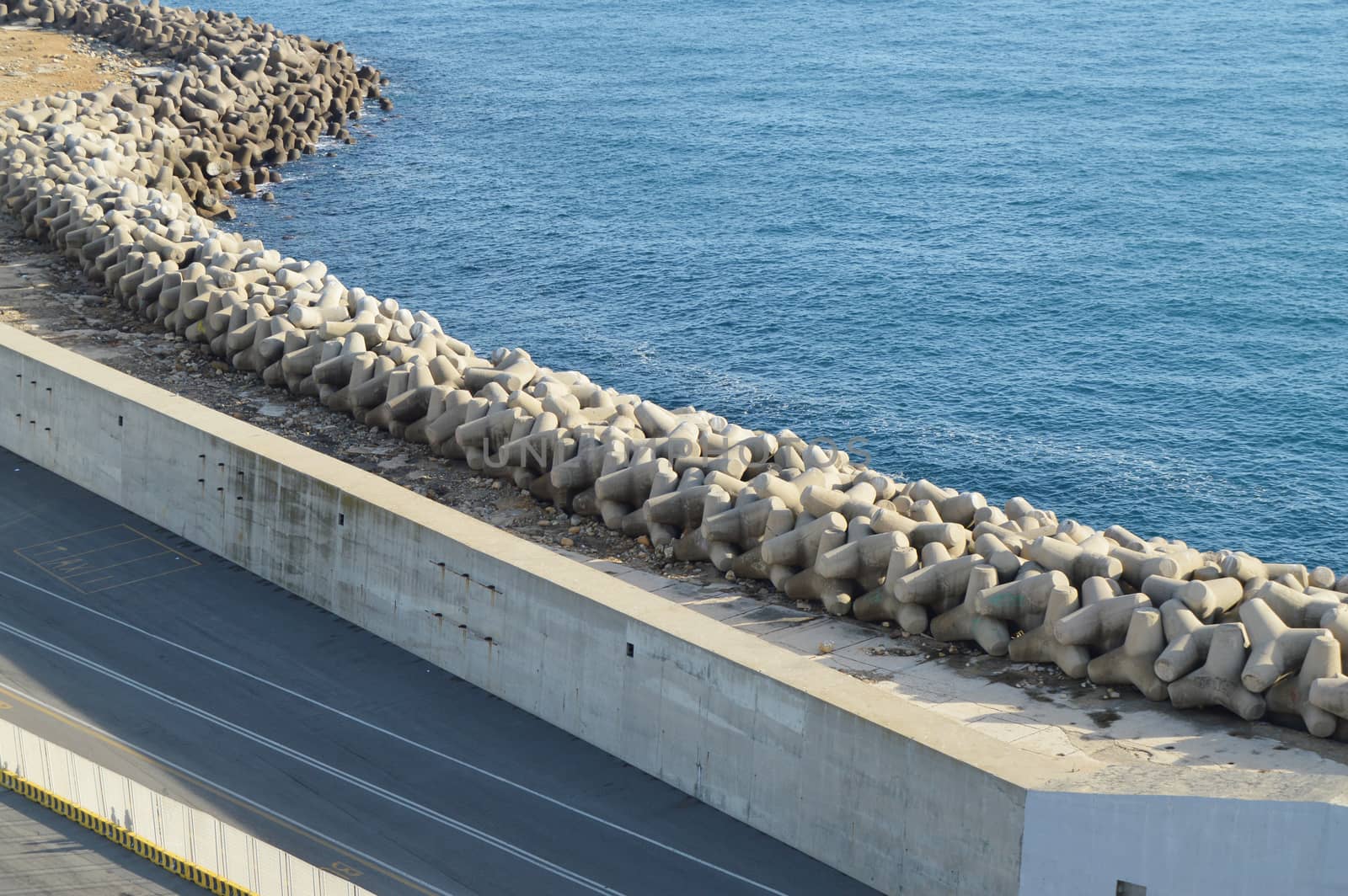 View of the stone and concrete breakwaters along the pier, the port of Civitavecchia, on 7 October 2018 by claire_lucia