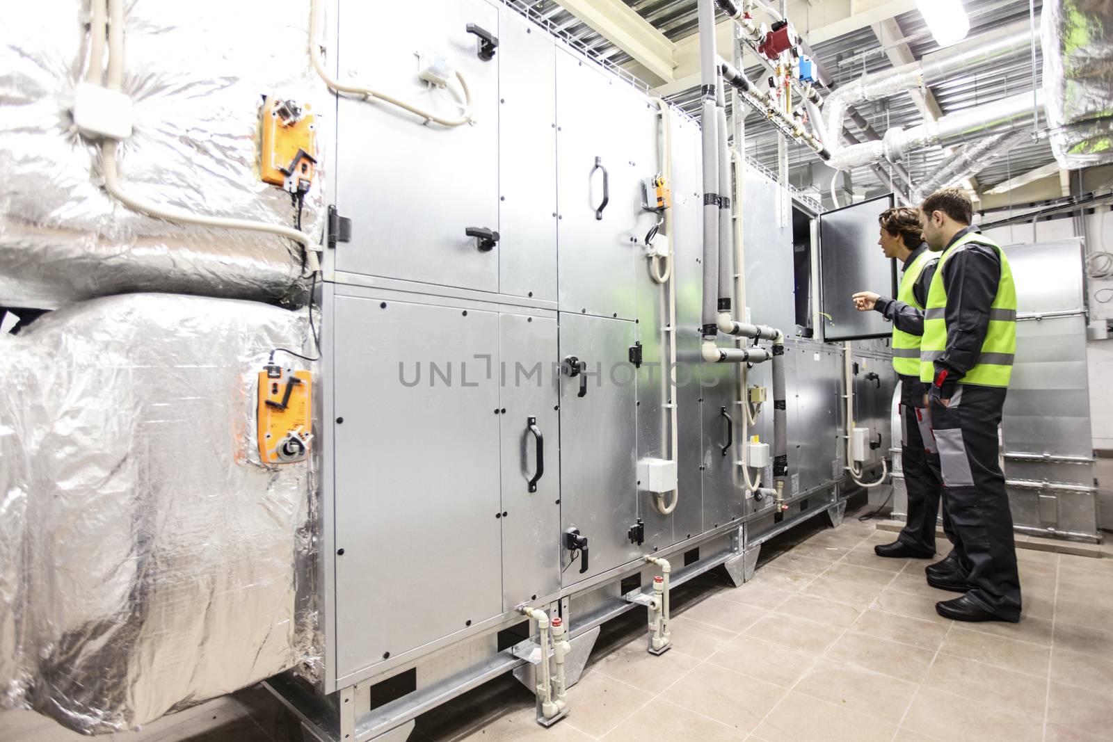 Workers in electrical switchgear room of CNC plant