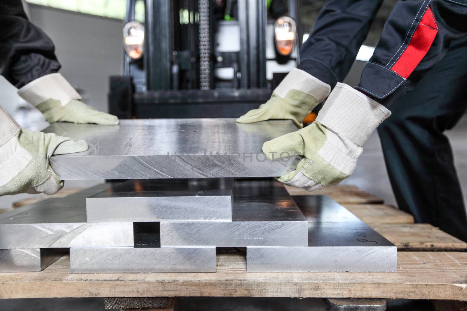 Workers taking aluminium billet at CNC machine shop