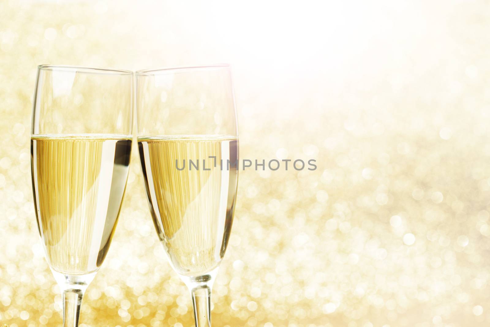 Champagne glasses on abstract shiny glitters background