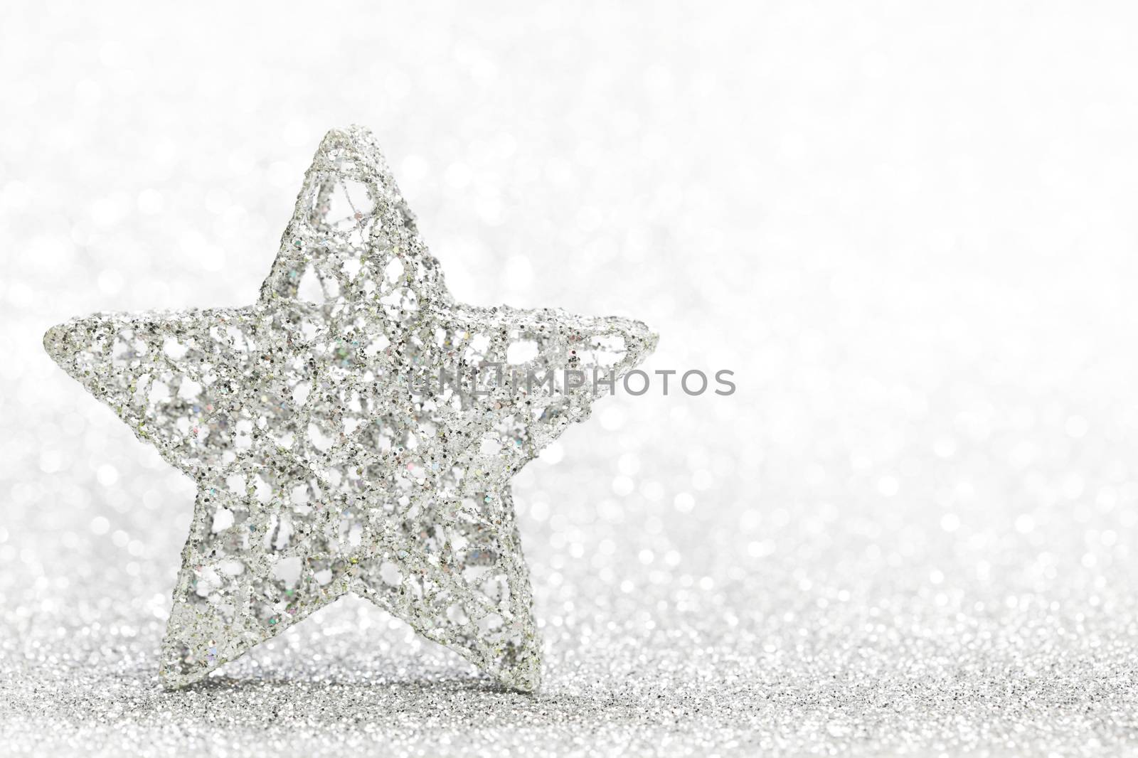 Christmas decorative star on light silver bokeh background