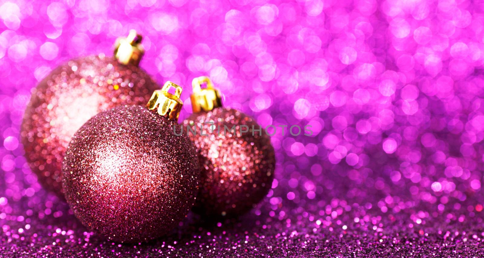 Beautiful Glitter purple christmas balls close-up on shining background