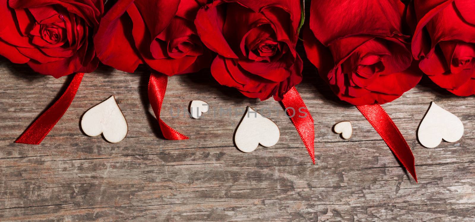 Roses ribbons and wooden hearts on wooden background, Valentines day