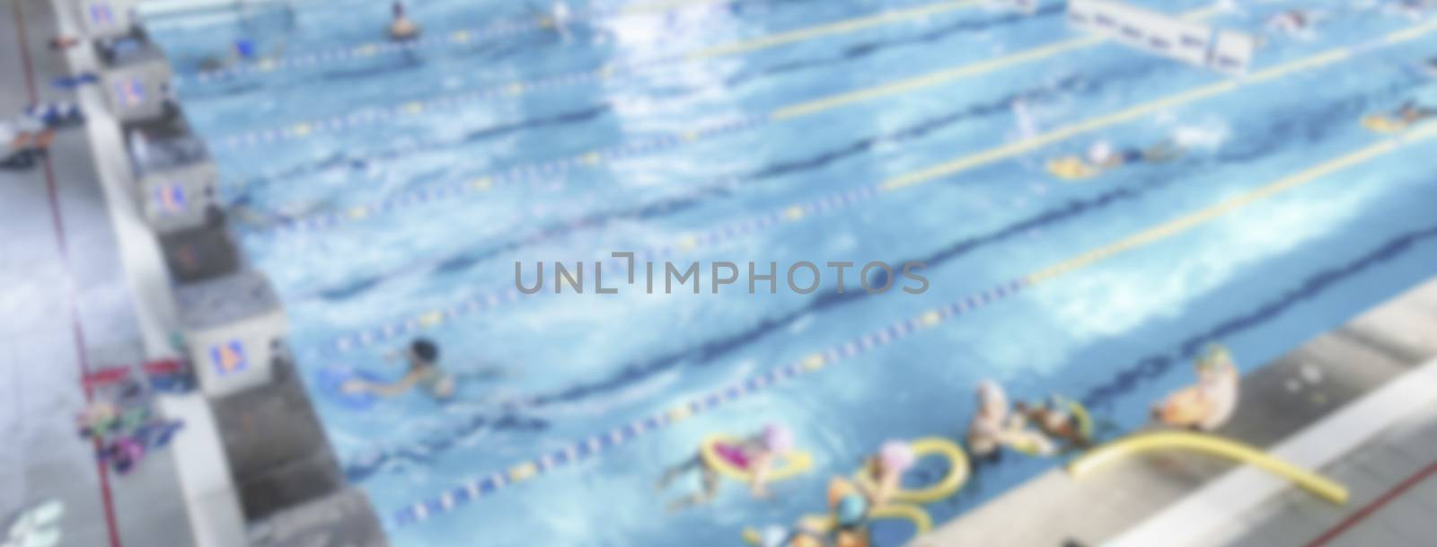Defocused background with aerial view of a swimming pool indoor. Intentionally blurred post production for bokeh effect