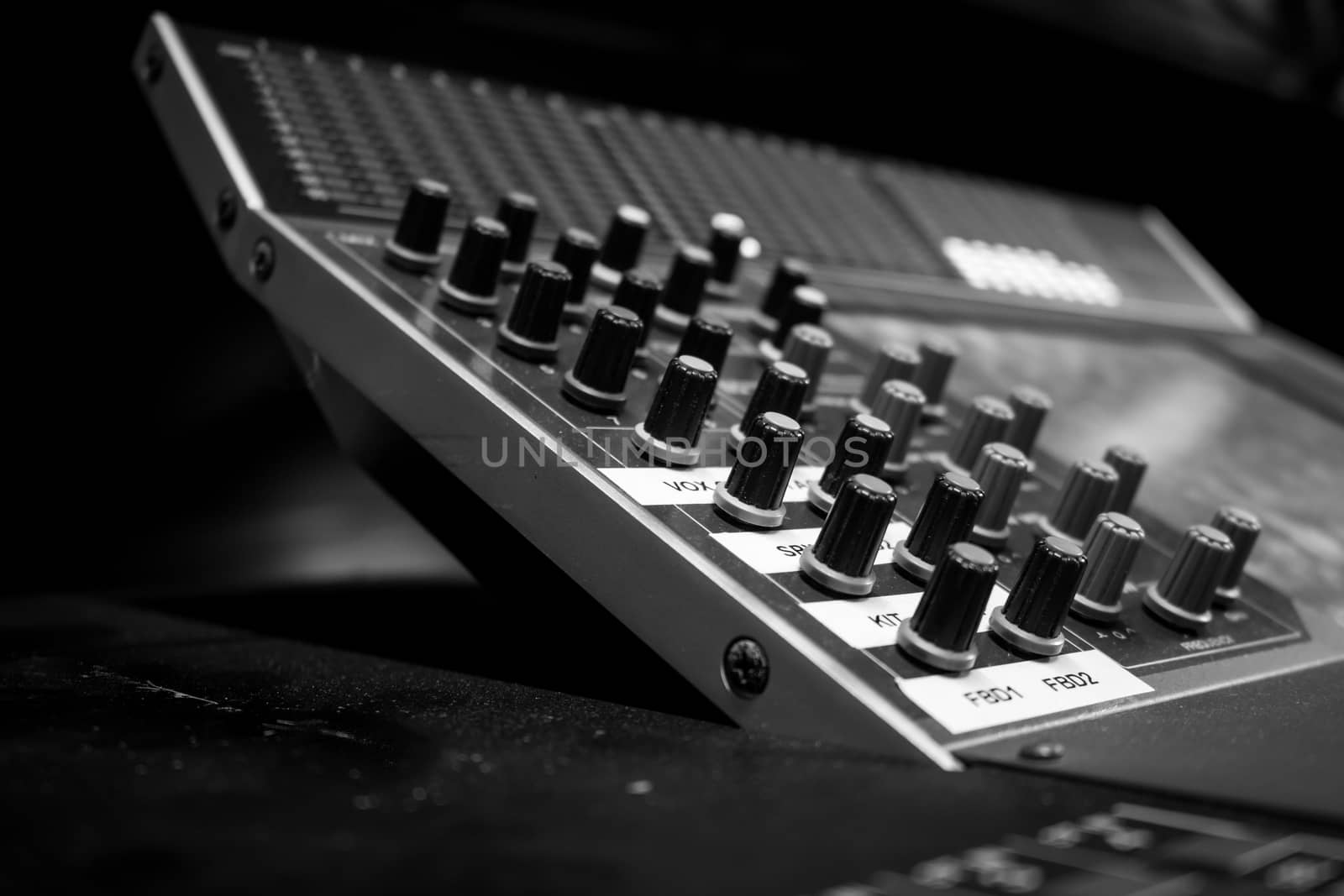 Closeup of Pro Audio Digital Mixing Console. Black control Console with digital dislpay in background