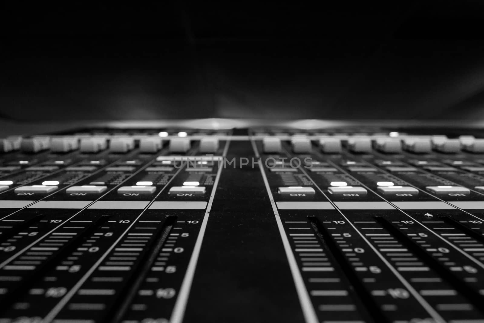 Wide angle closeup of Pro Audio Digital Mixing Console. White Faders and black control Console