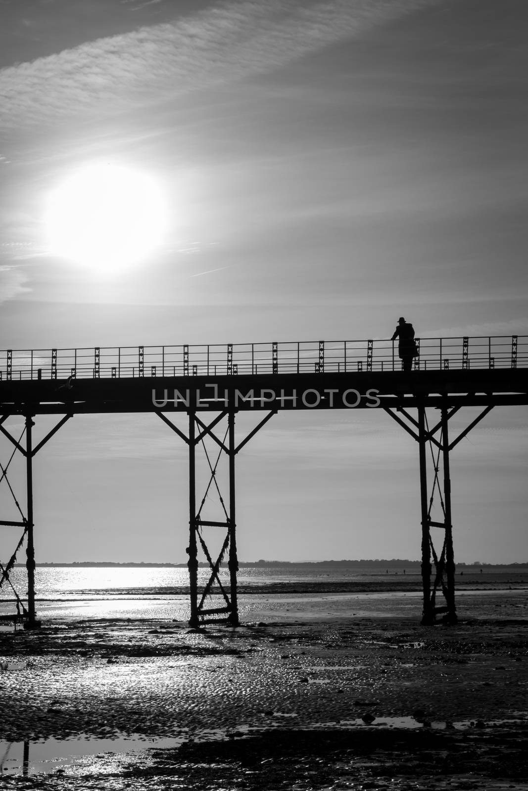 Monochrome single man thinking on an old english victorian seaside pier