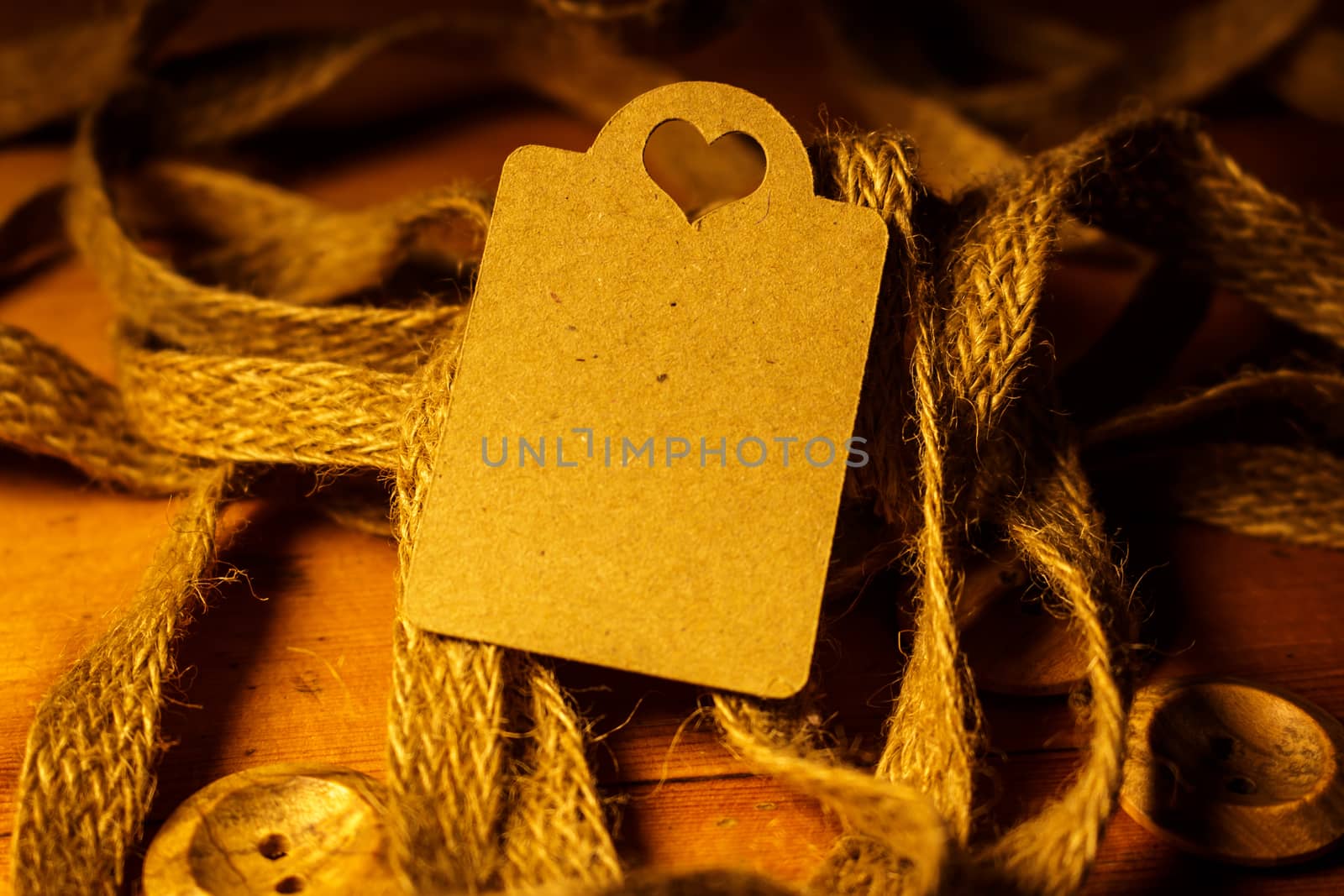 Rectangle Heart Shaped Valentines day gift card tag on wooden background with vintage rustic twine and old buttons