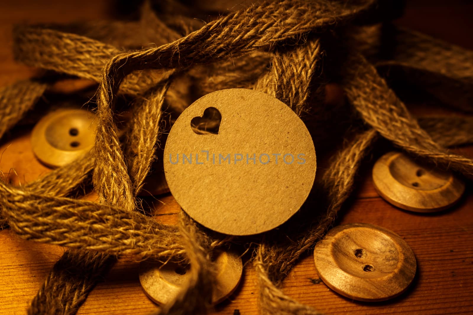 Round Circle Valentines day gift card tag on wooden background with vintage rustic twine and old buttons