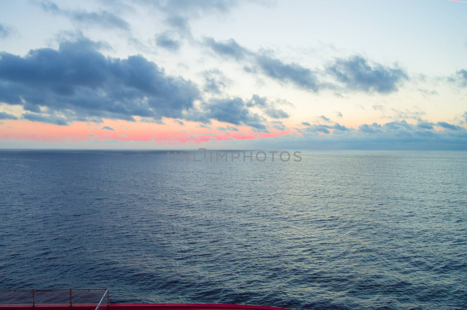 Beautiful sunset and silver path on the sea, blue clouds in the sky, background.