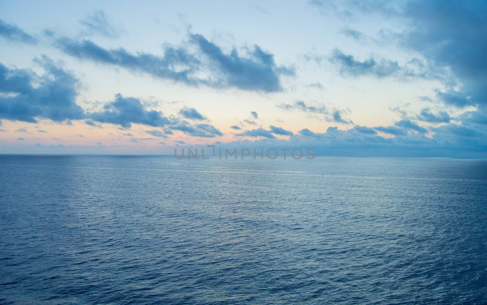 Beautiful sunset and silver path on the sea, blue clouds in the sky, background.