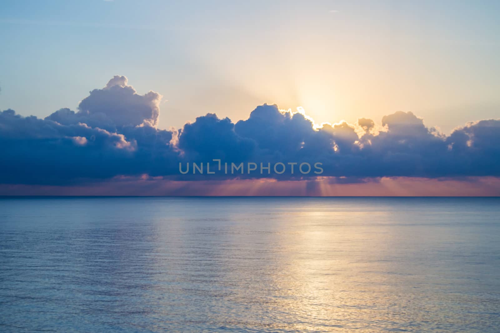 Beautiful sunset and silver path on the sea, blue clouds in the sky, background by claire_lucia