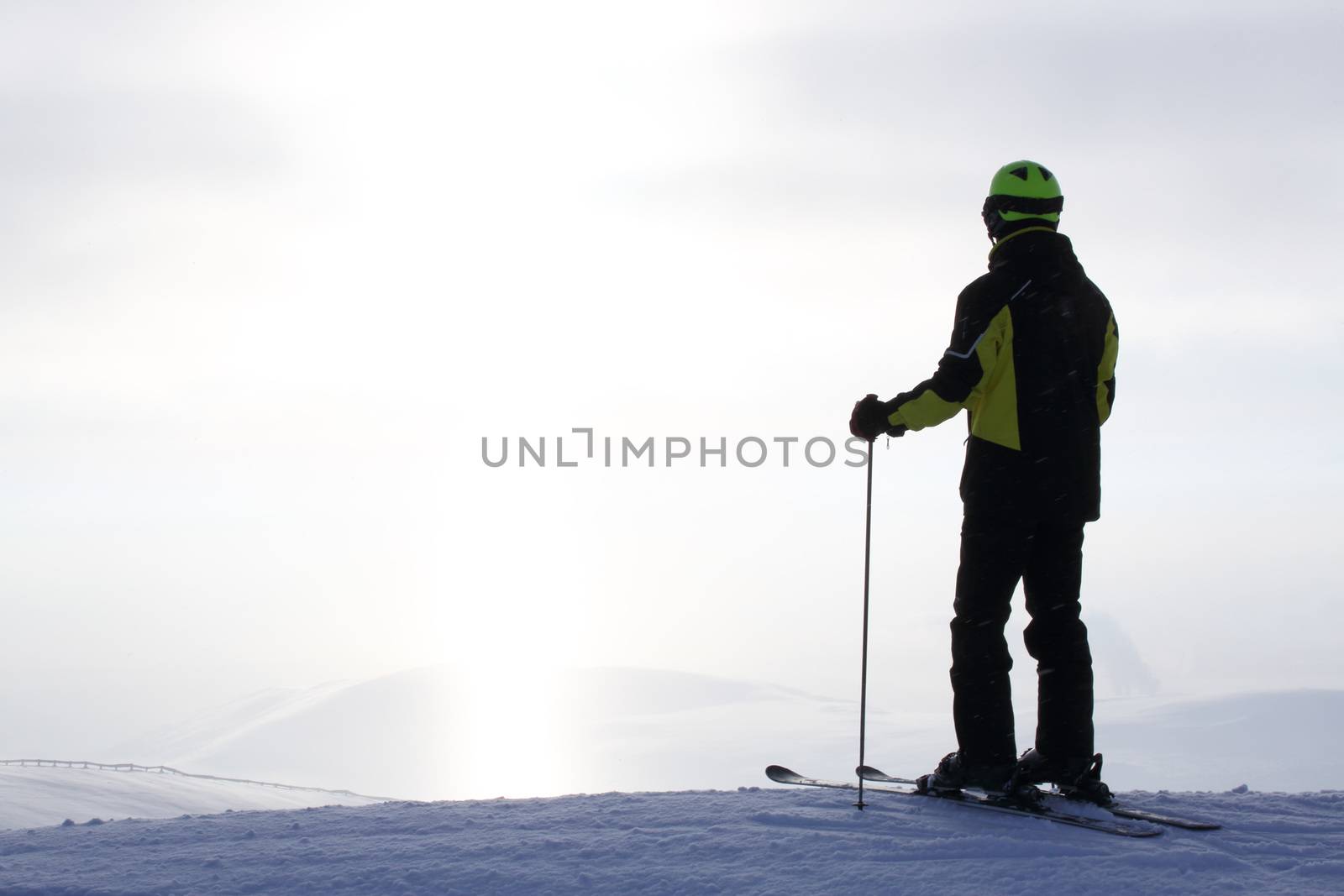 Skier on ski slope with mountains in background