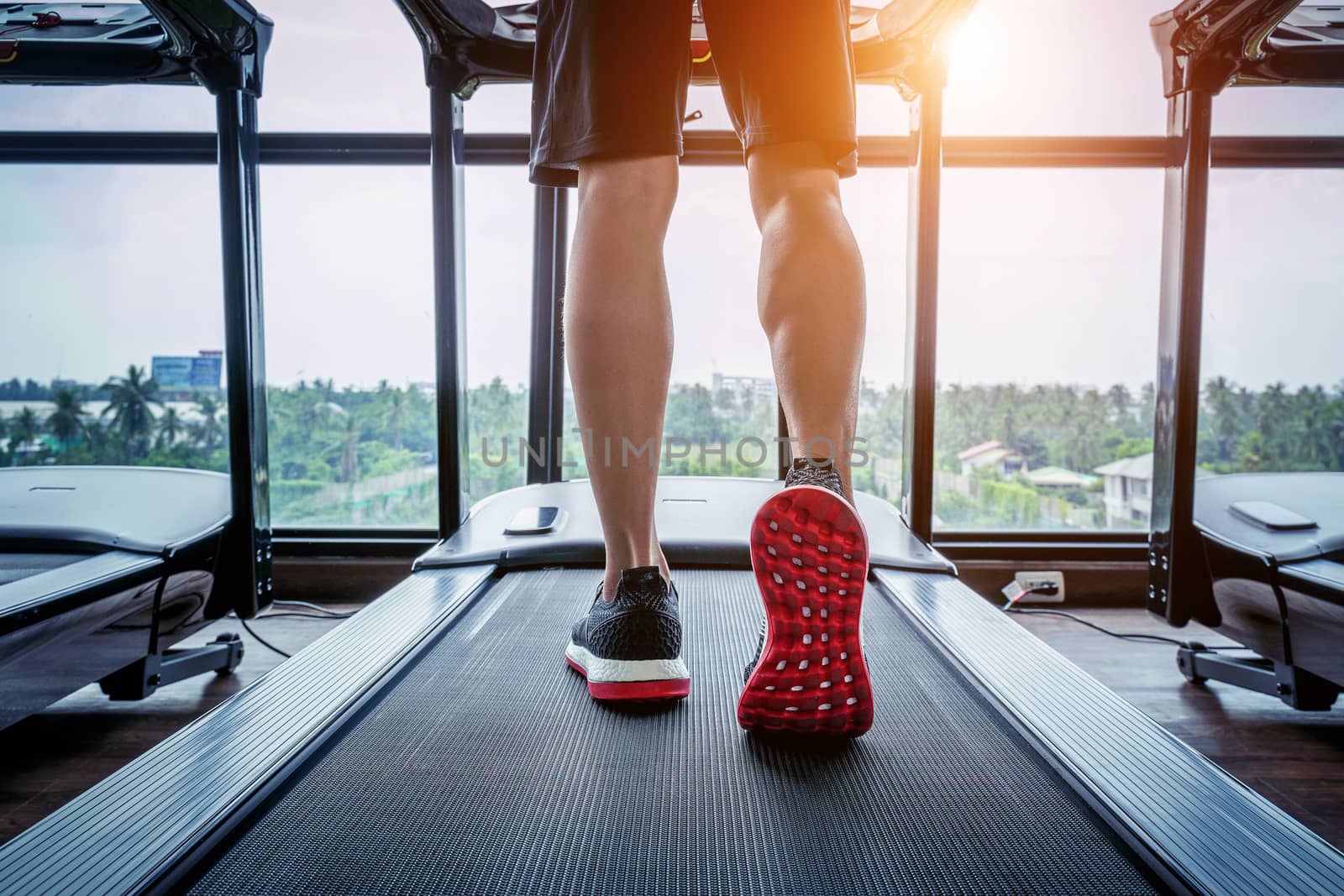 Male feet in sneakers running on the treadmill at the gym. Exercise concept. by gutarphotoghaphy